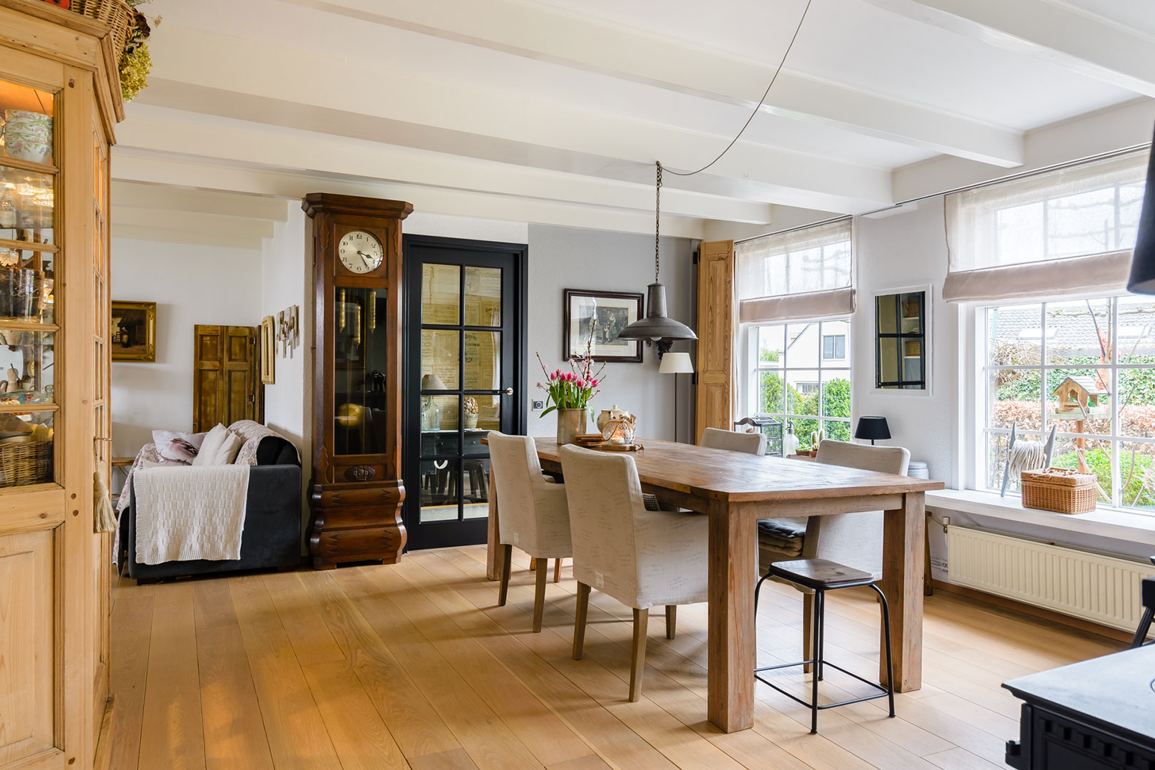 Karakteristieke eetkamer met houten tafel en grote ramen